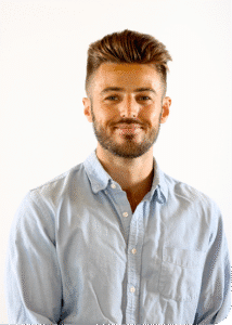 Headshot of Kent McDonald smiling in a light blue button-down shirt